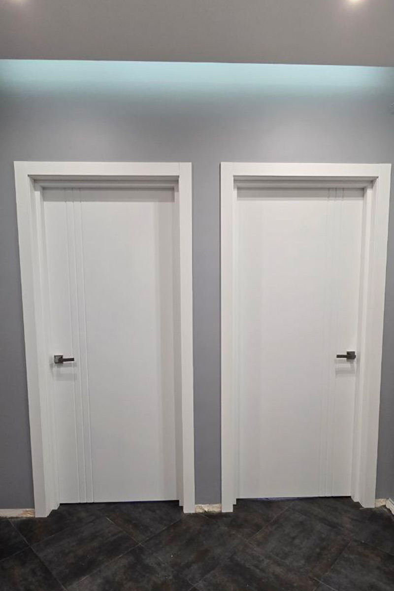 Белая дверь на фоне серой стены