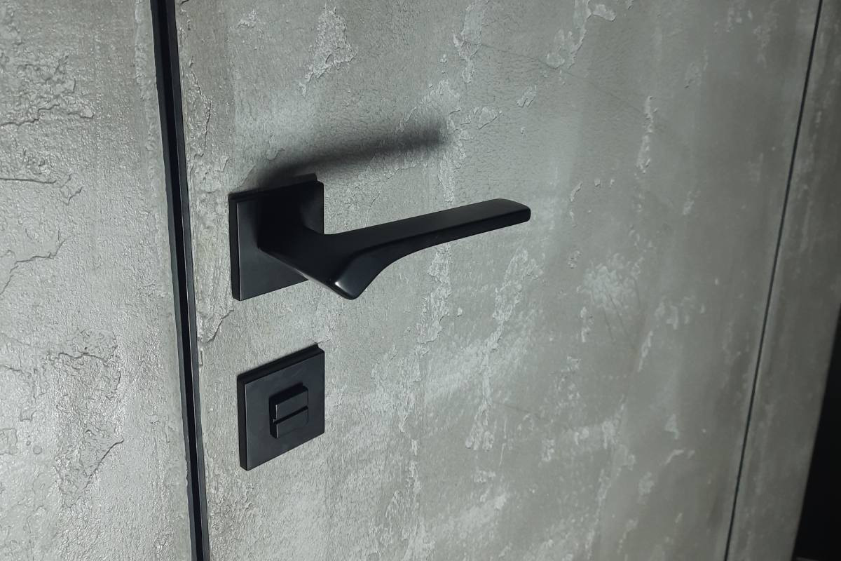 Приховані двері з чорною алюмінієвою окантовкою з нанесеною фактурною штукатуркою